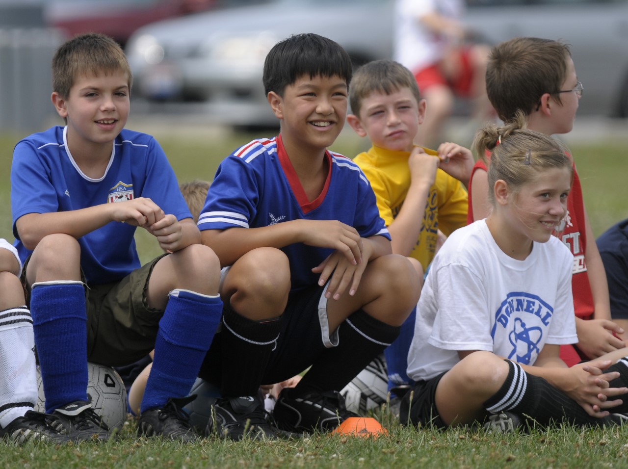 Two soccer players, a boy and girl, challenge for the ball